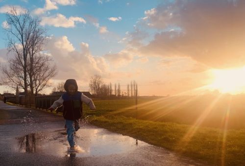 Kind speelt bij zonsondergang